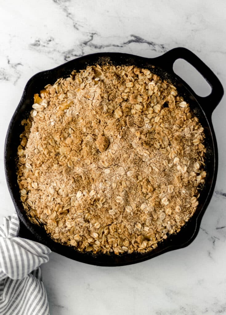 overhead view of freshly baked peach crisp in cast iron skillet