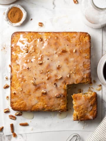 Overhead view hummingbird coffee cake topped with pecans on parchment paper