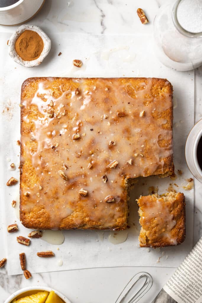 overhead view hummingbird coffee cake on parchment paper topped with pecans. 