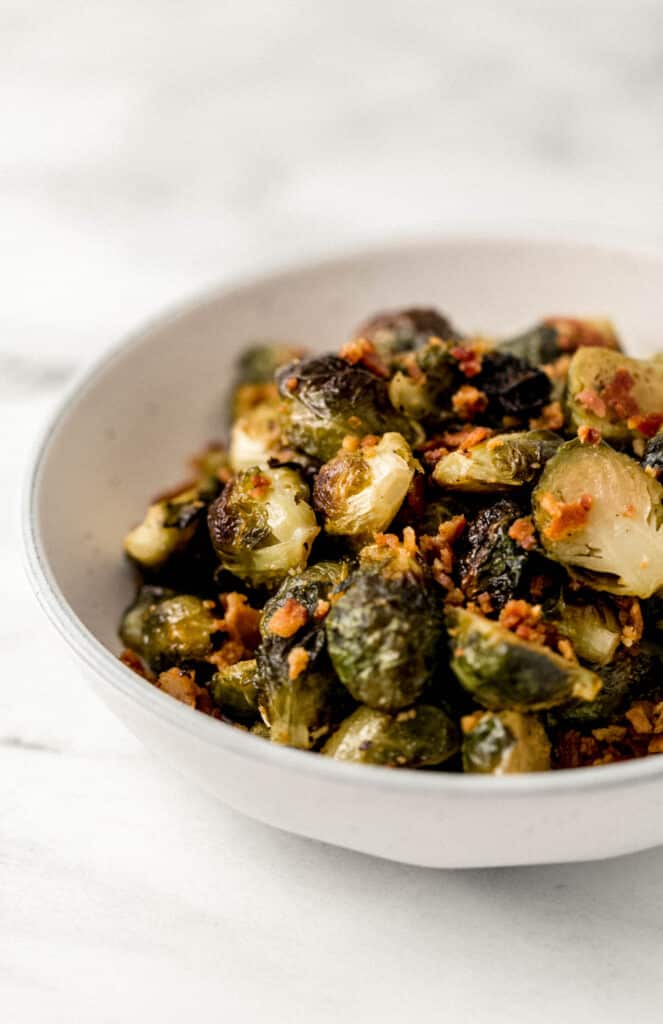 close up side view brussels sprouts in white bowl 