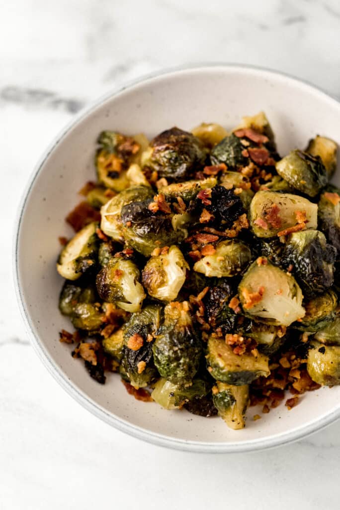 close up view white bowl of maple roasted brussels sprouts