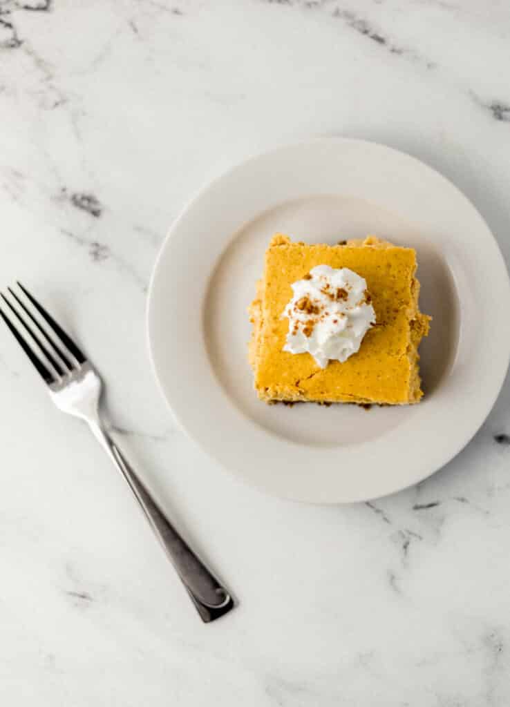 overhead view square cheesecake slice on white plate with fork