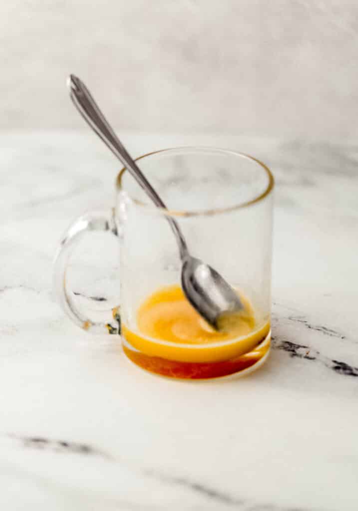 ingredients needed to make cling peach medicine ball in glass mug with spoon
