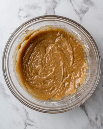 Overhead view of bar ingredients combined in glass mixing bowl.