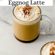 Close up front view of latte in glass mug on pin with text overlay.