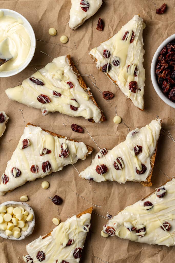 overhead view of finished homemade cranberry bliss bars on brown parchment paper