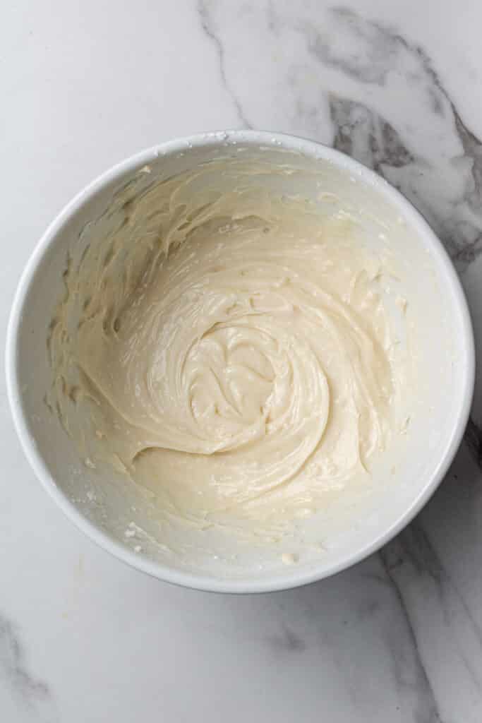 white mixing bowl with ingredients for frosting mixture combined