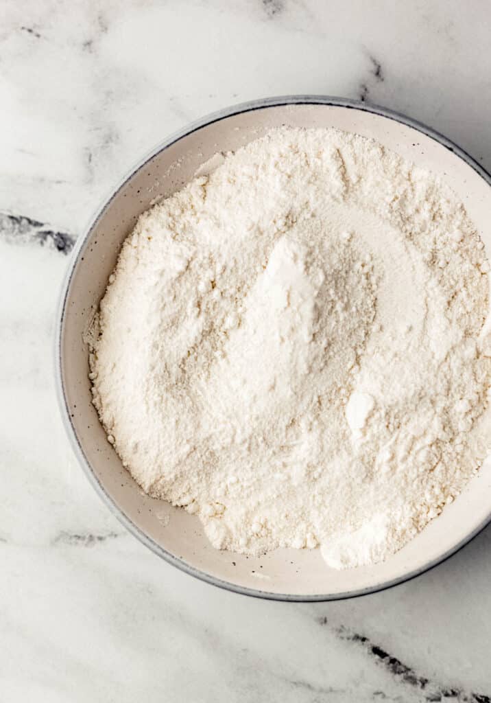 overhead view of flour, sugar, and salt combined in white bowl 