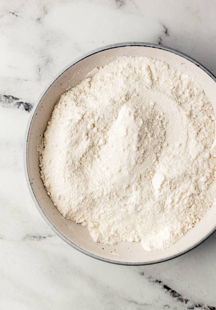 overhead view of flour, sugar, and salt combined in white bowl