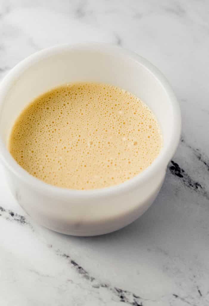 flour mixture and milk combined in white mixing bowl 