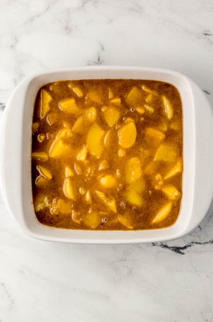 peach mixture for cobbler in square white baking dish 