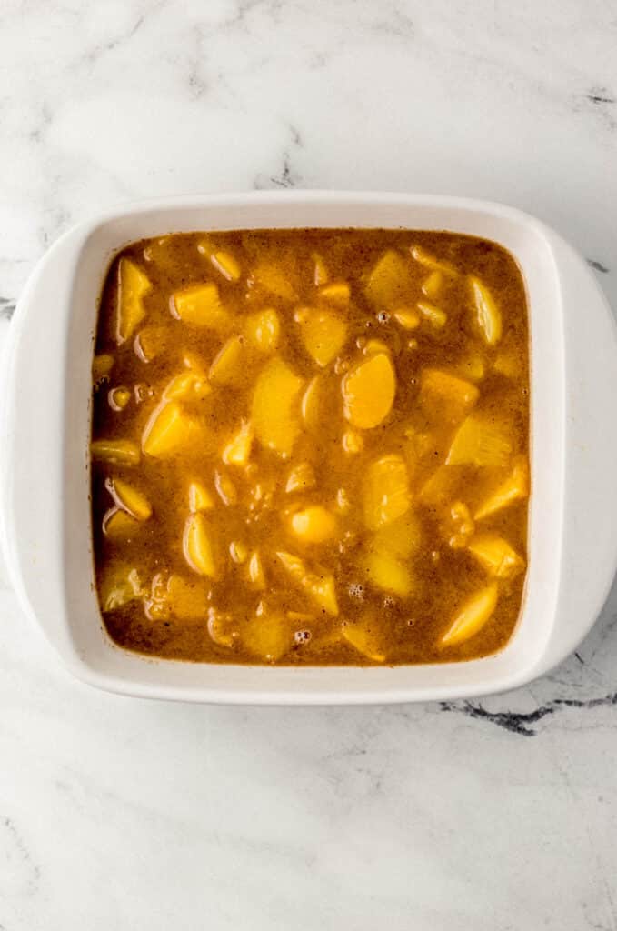 peach mixture for cobbler in square white baking dish