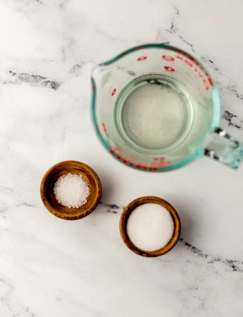 vinegar, salt, and sugar in separate containers on marble surface 