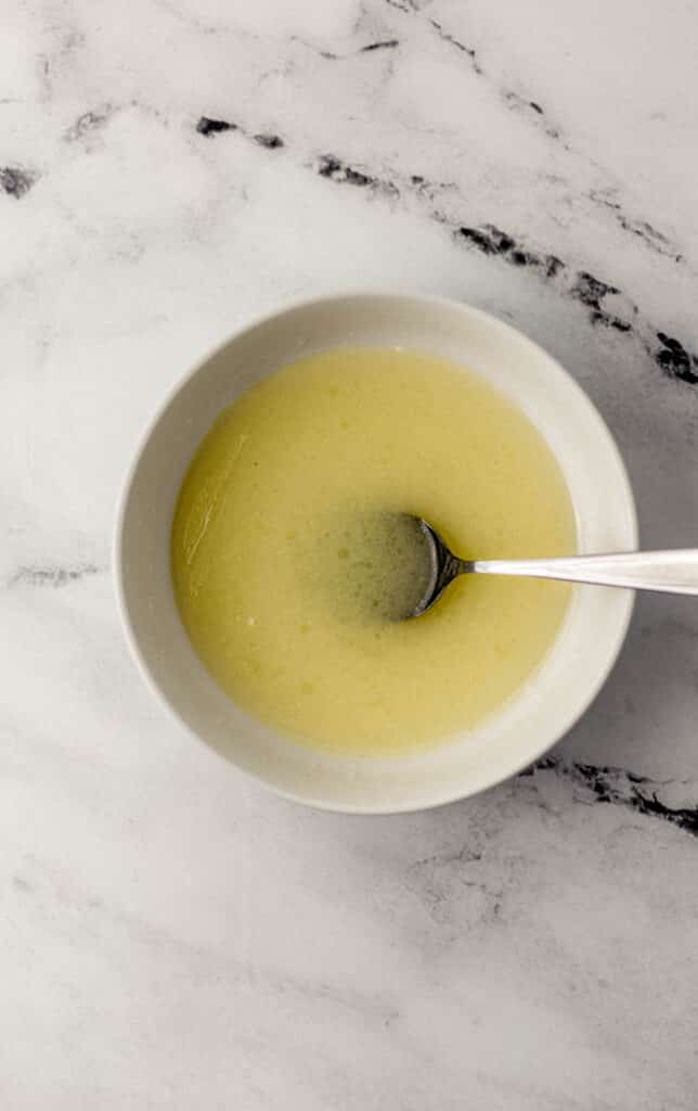 wet ingredients combined in white bowl with spoon