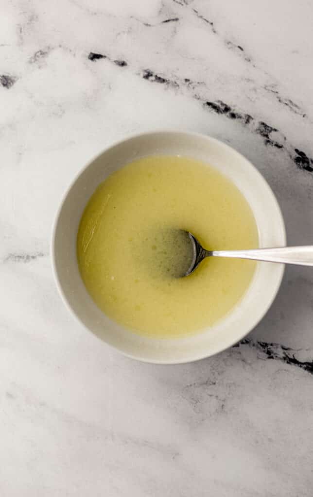 wet ingredients combined in white bowl with spoon 