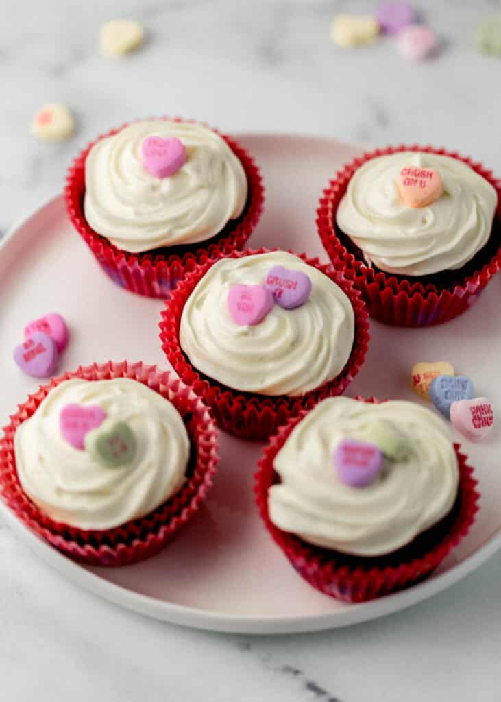 close up side view finished red velvet cupcakes on white plate