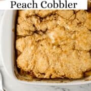 Close up view of finished peach cobbler in baking dish on pin with text overlay.