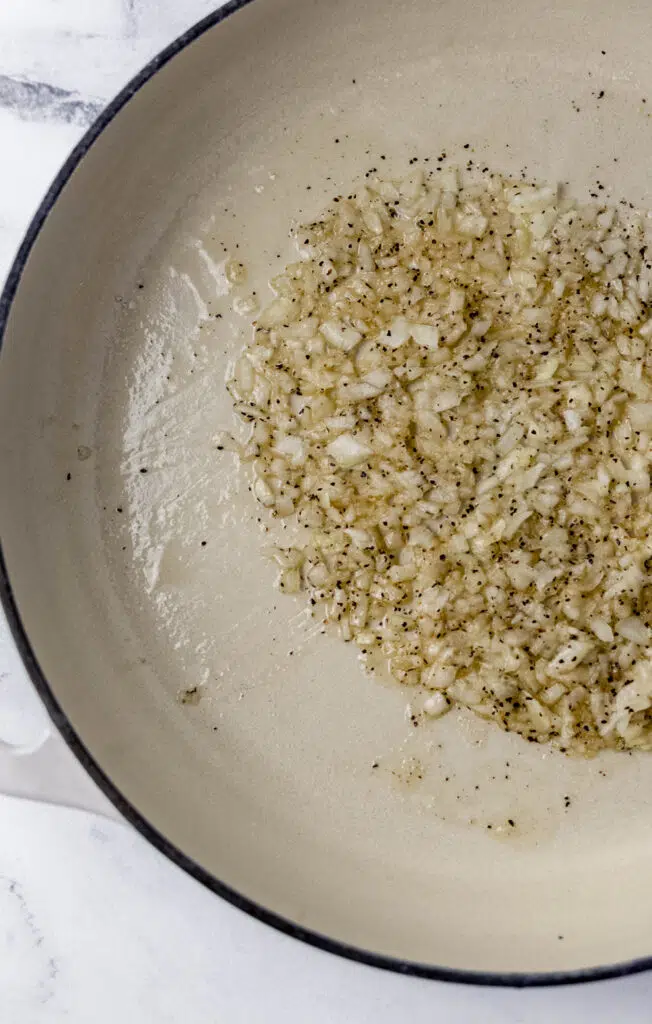 onion, sugar, salt, and black pepper in pan with melted butter 