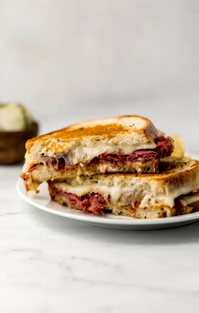 grilled cheese sandwich cut in half on white plate 