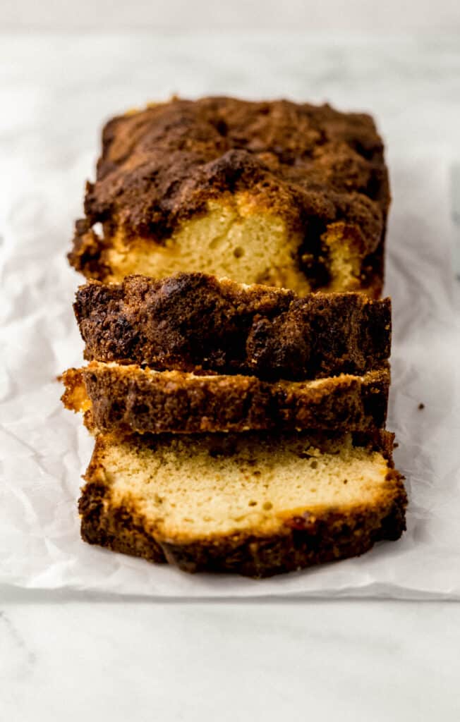 close up side view of sliced peach bread on parchment paper