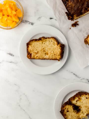 overhead view of peach bread on white plates and on marble surface