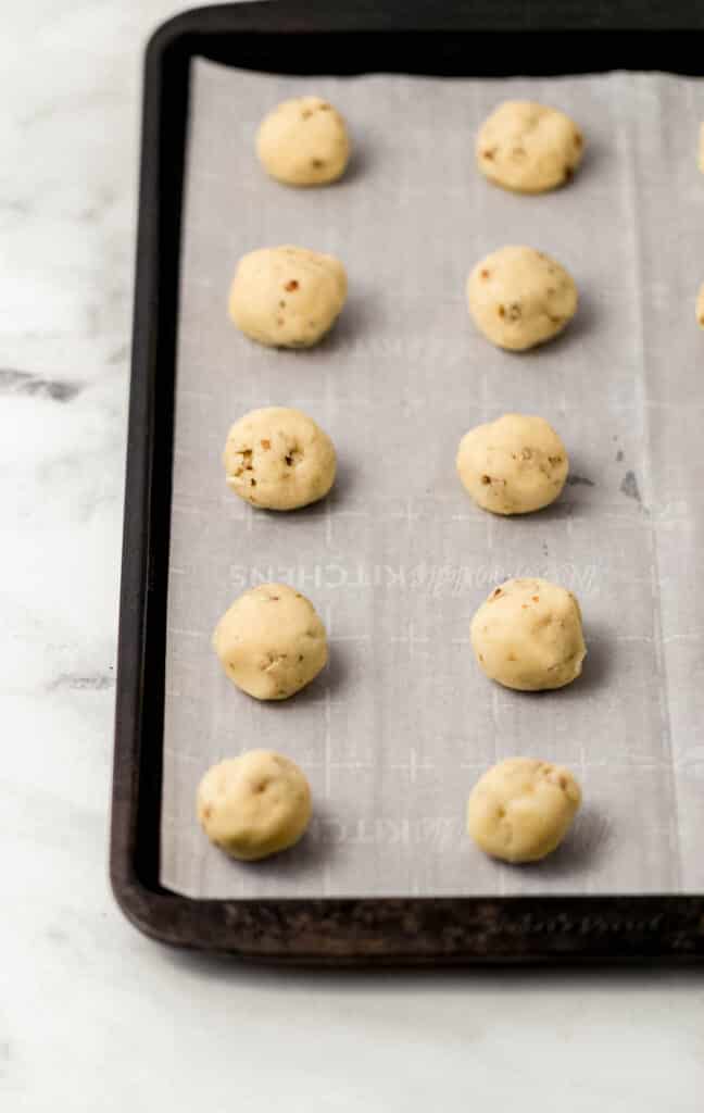 cookie dough balls on parchment lined baking sheet 