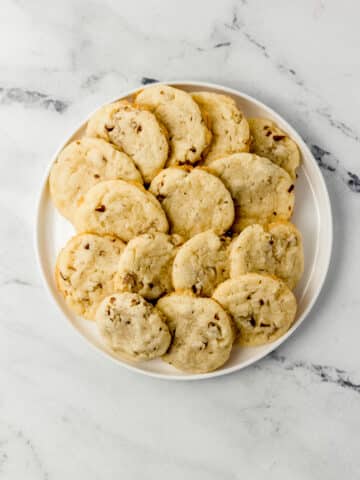 overhead view pecan sandies on white plate on top of marble surface