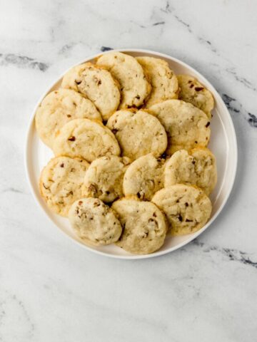 overhead view pecan sandies on white plate on top of marble surface
