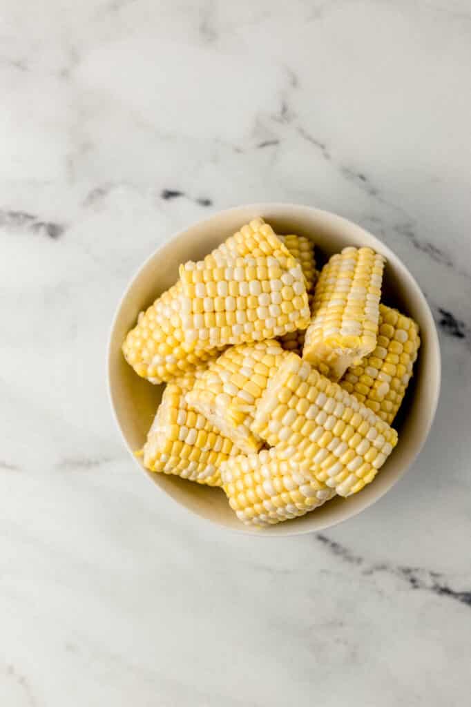 shucked and cut pieces of fresh corn in white bowl
