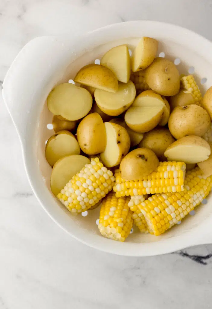 parboiled potatoes and corn in large white strainer