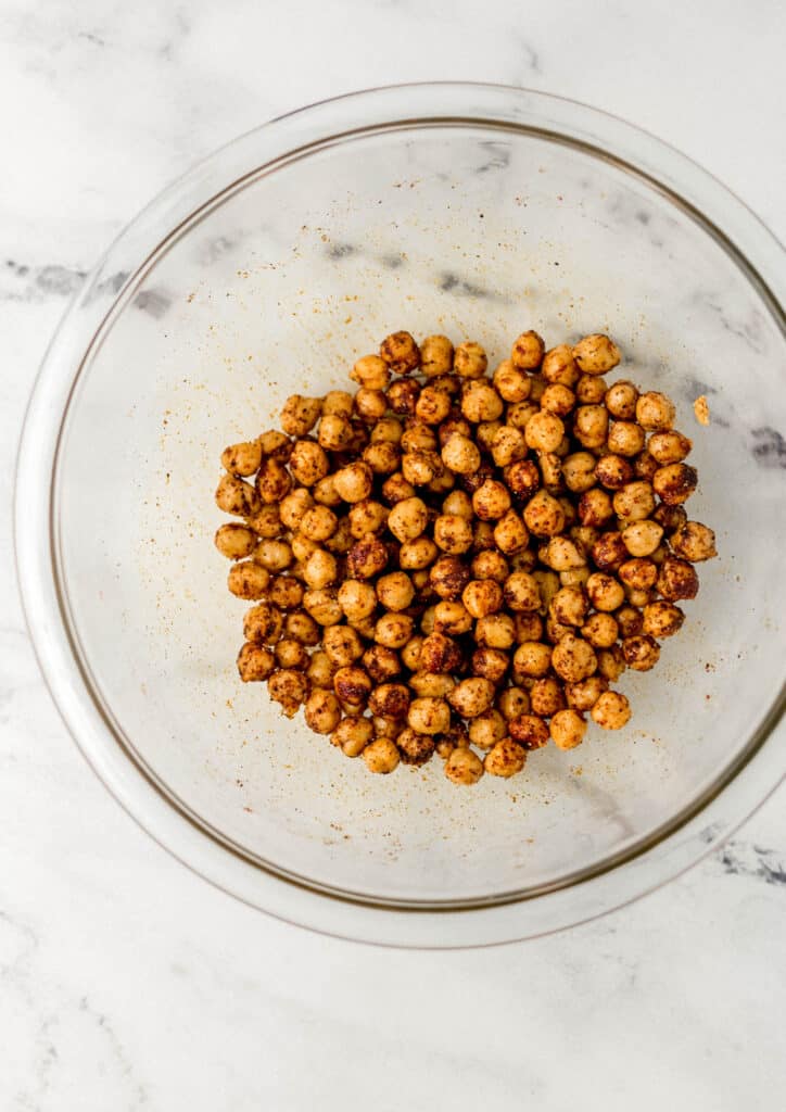 large glass bowl with chickpeas, spices, and olive oil
