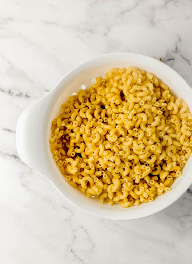 cooked pasta in white strainer