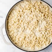 Overhead view of white cheddar mac and cheese is large white braiser.