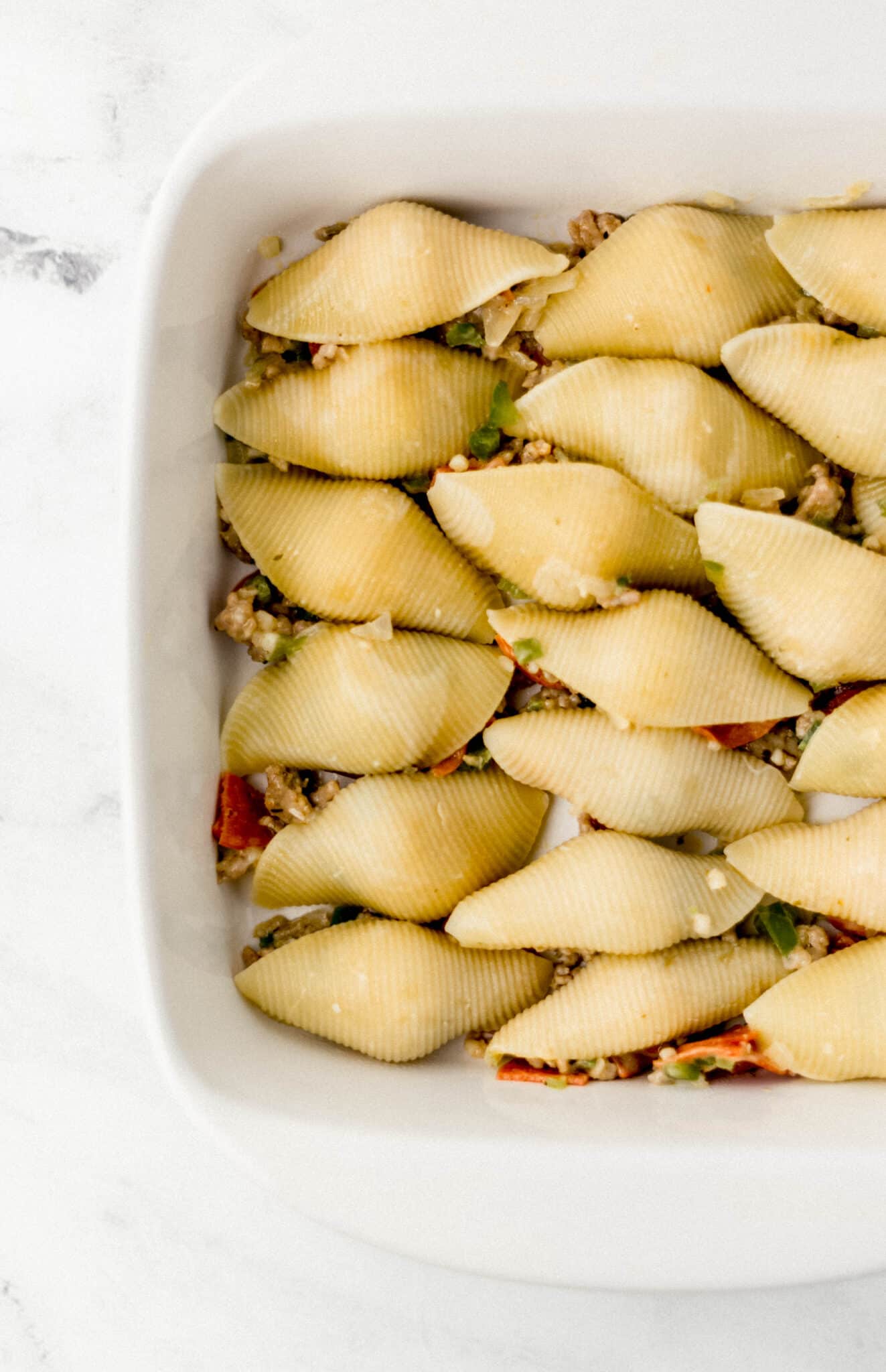 stuffed pasta shells in white baking dish 