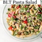 Overhead view of finished pasta salad in large glass bowl on pin with text overlay.