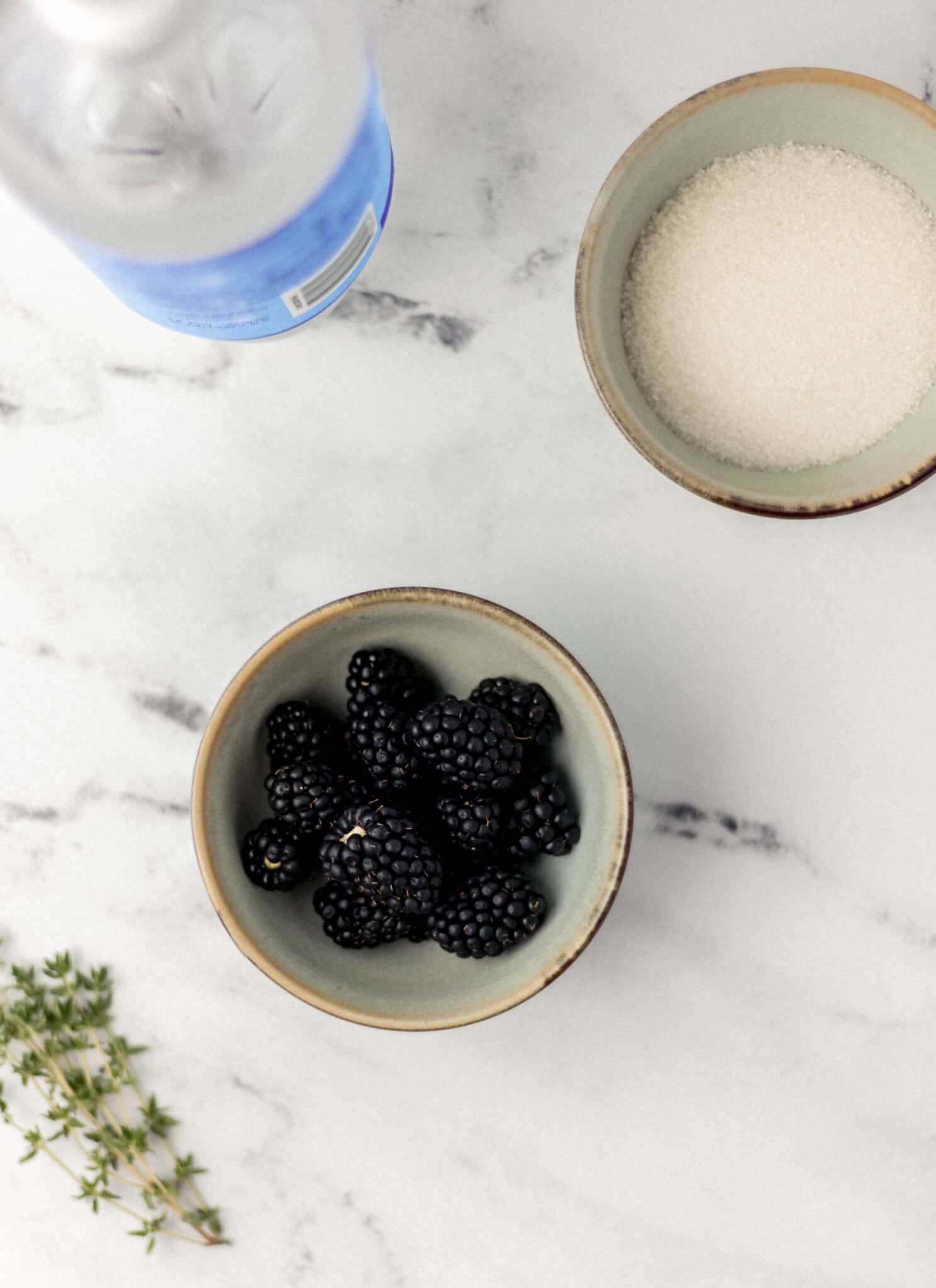 overhead view of ingredients to make blackberry thyme mocktail in separate small bowls