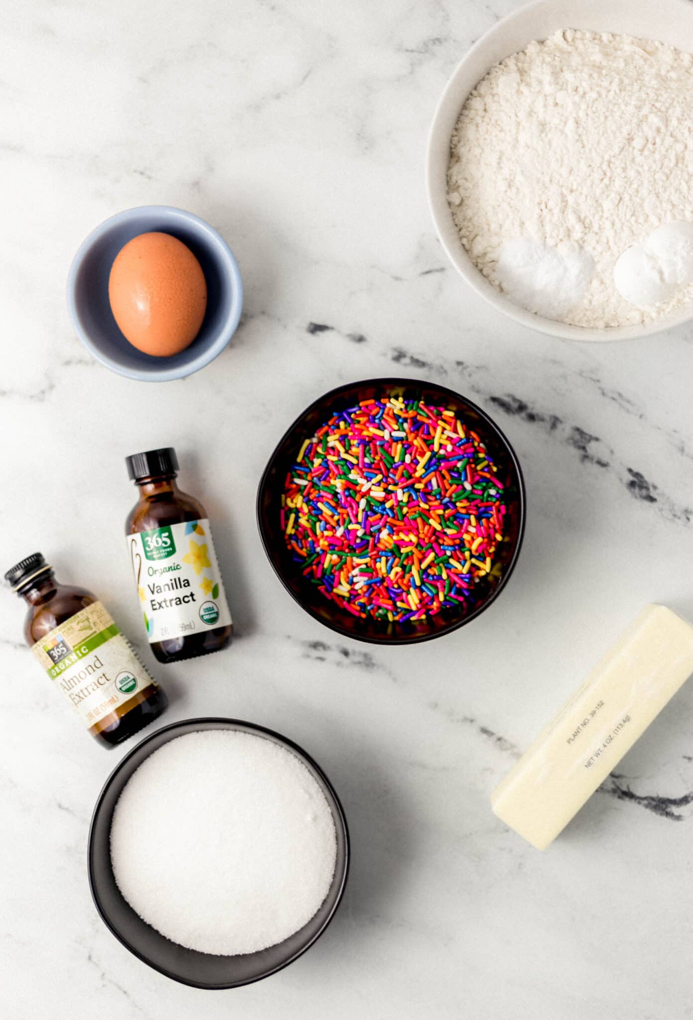 ingredients needed to make cookies in separate containers on marble