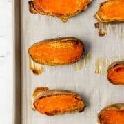 Overhead view of roasted potatoes on parchment lined sheet pan.