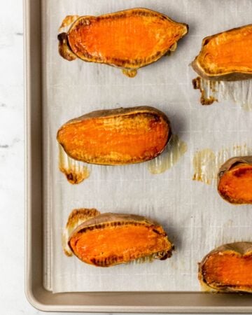 Overhead view of roasted potatoes on parchment lined sheet pan.