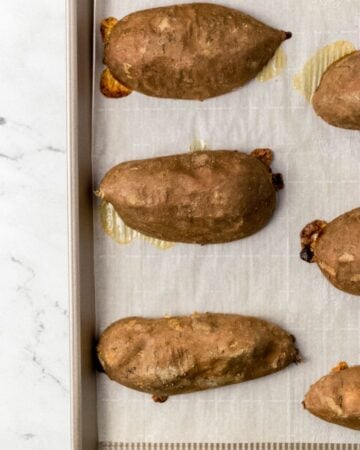 Roasted sweet potatoes on parchment lined sheet pan.