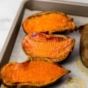 Close up front view of finished sweet potatoes on parchment lined sheet pan.