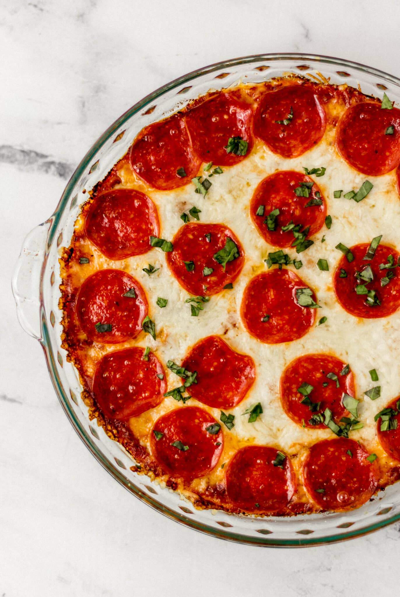 baked pizza dip topped with fresh chopped basil