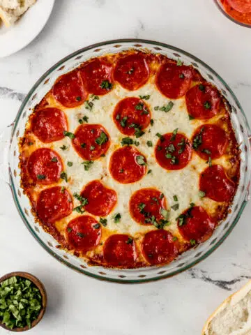 overhead view of pepperoni pizza dip in glass baking dish