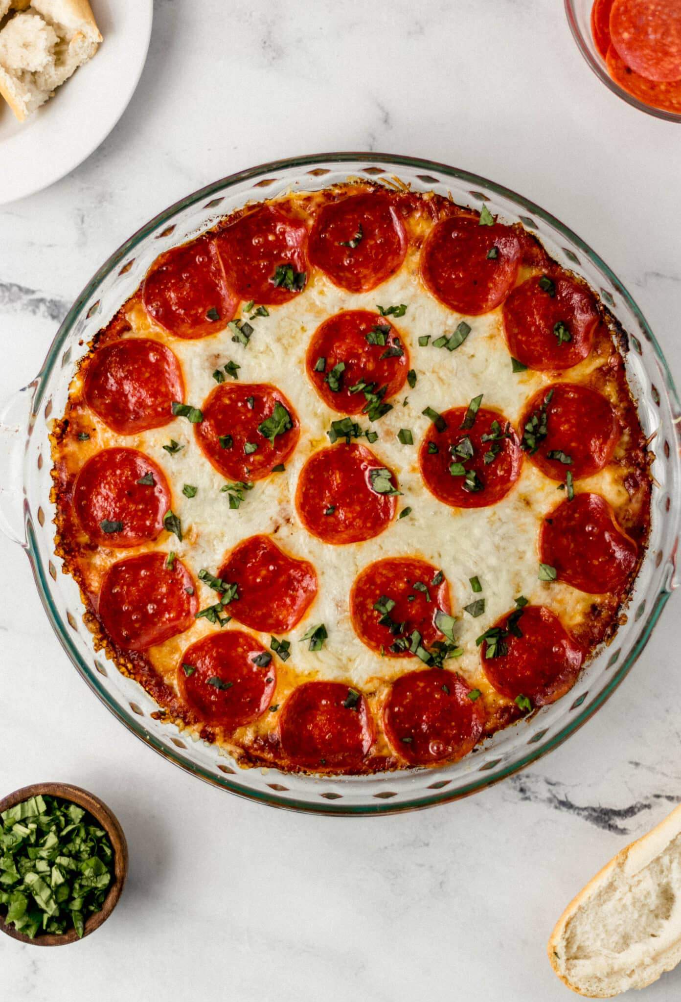 overhead view of baked pepperoni pizza dip in glass baking dish