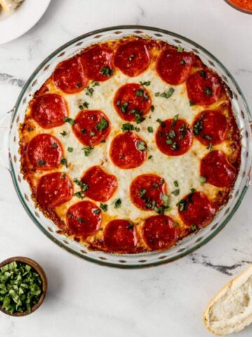 overhead view of pepperoni pizza dip in glass baking dish