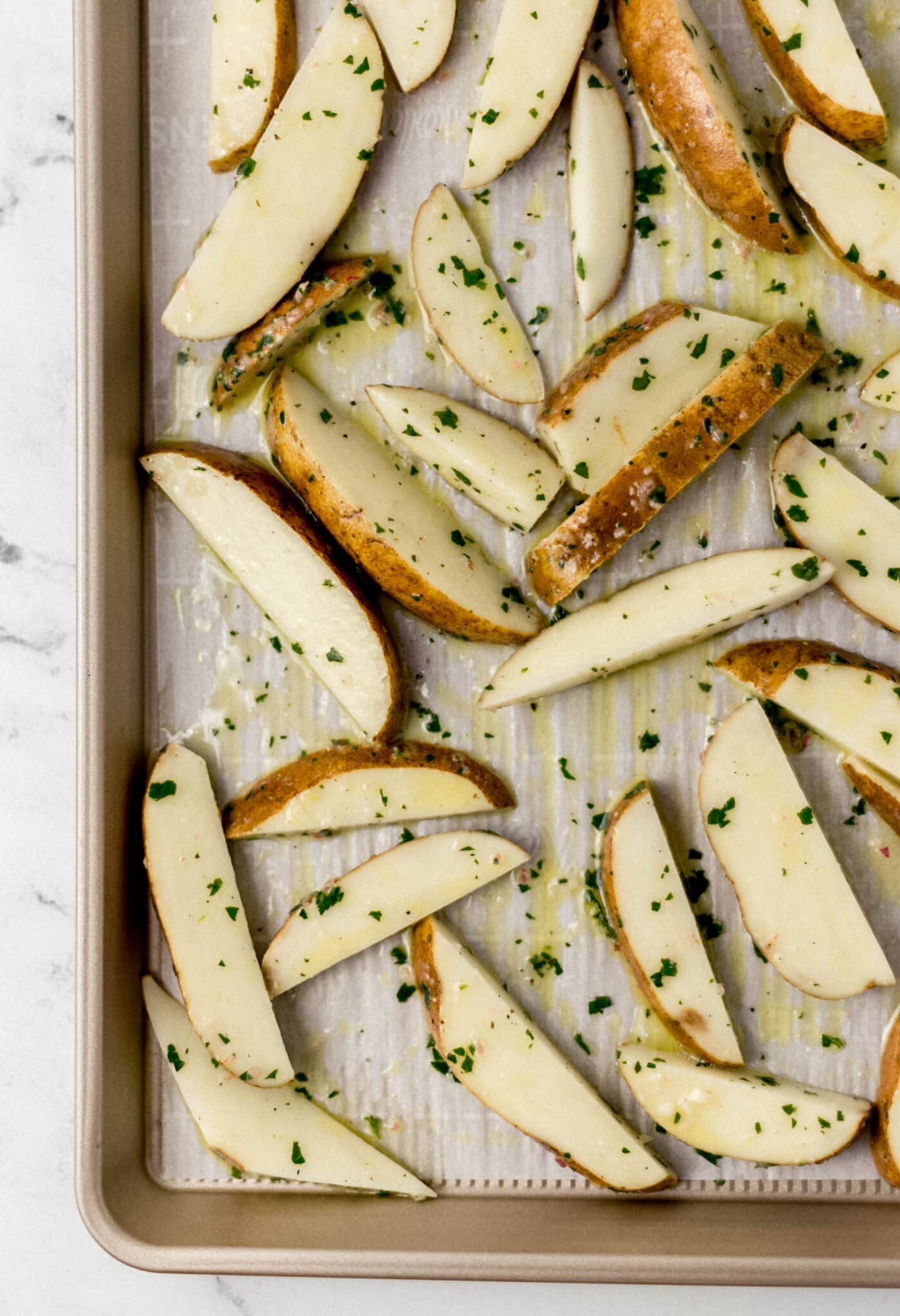 unbaked potatoes on parchment lined baking sheet 