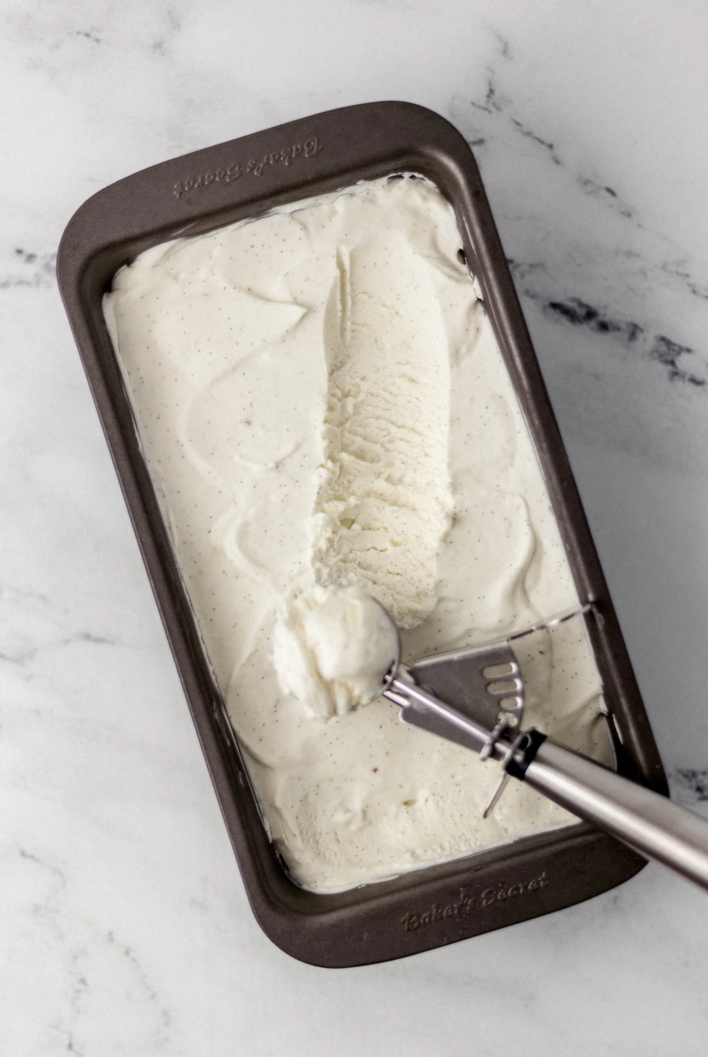 frozen ice cream in a loaf pan with ice cream scoop