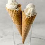 two ice cream cones with vanilla ice cream scoops in a glass