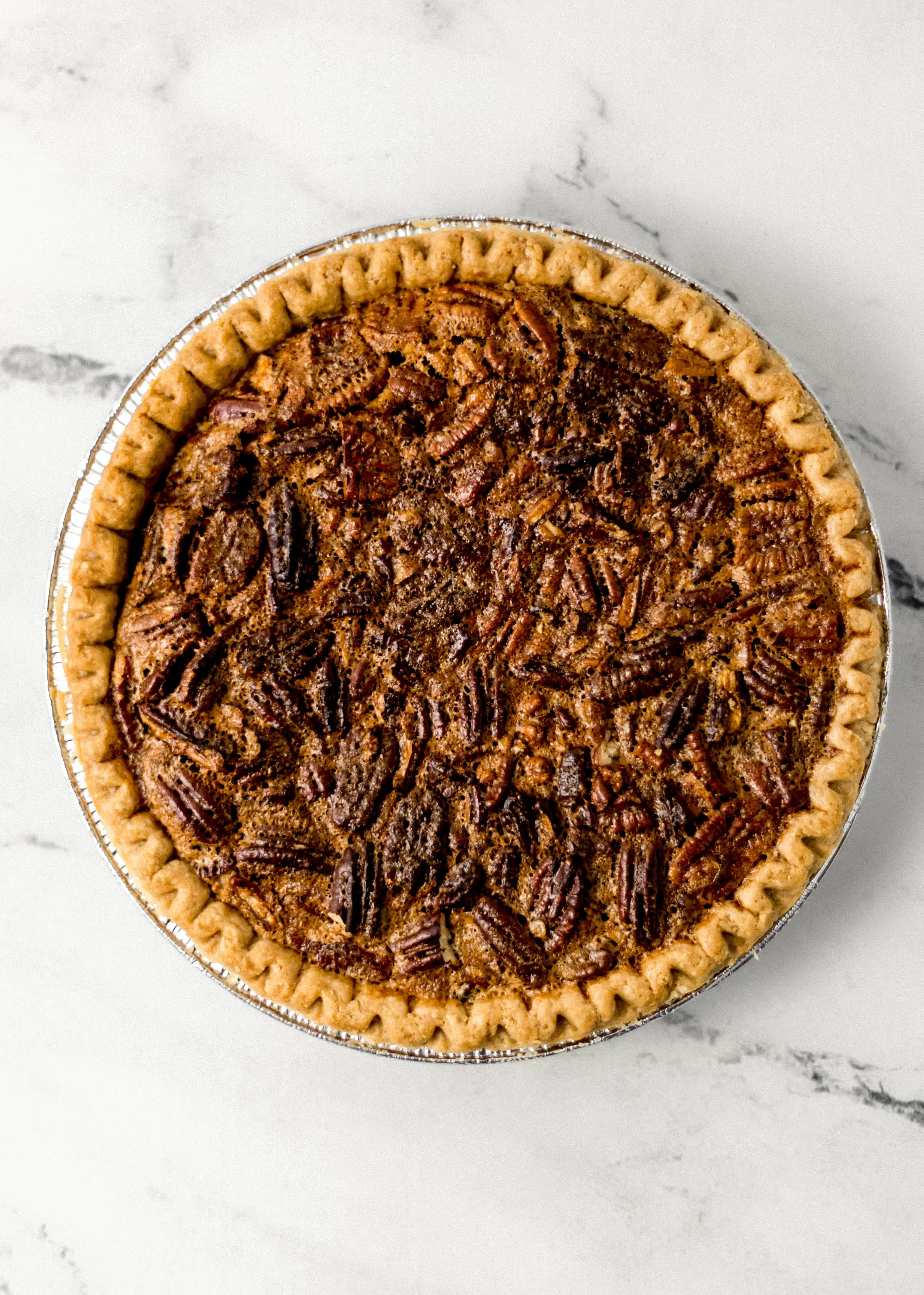 whole pecan pie on marble surface 