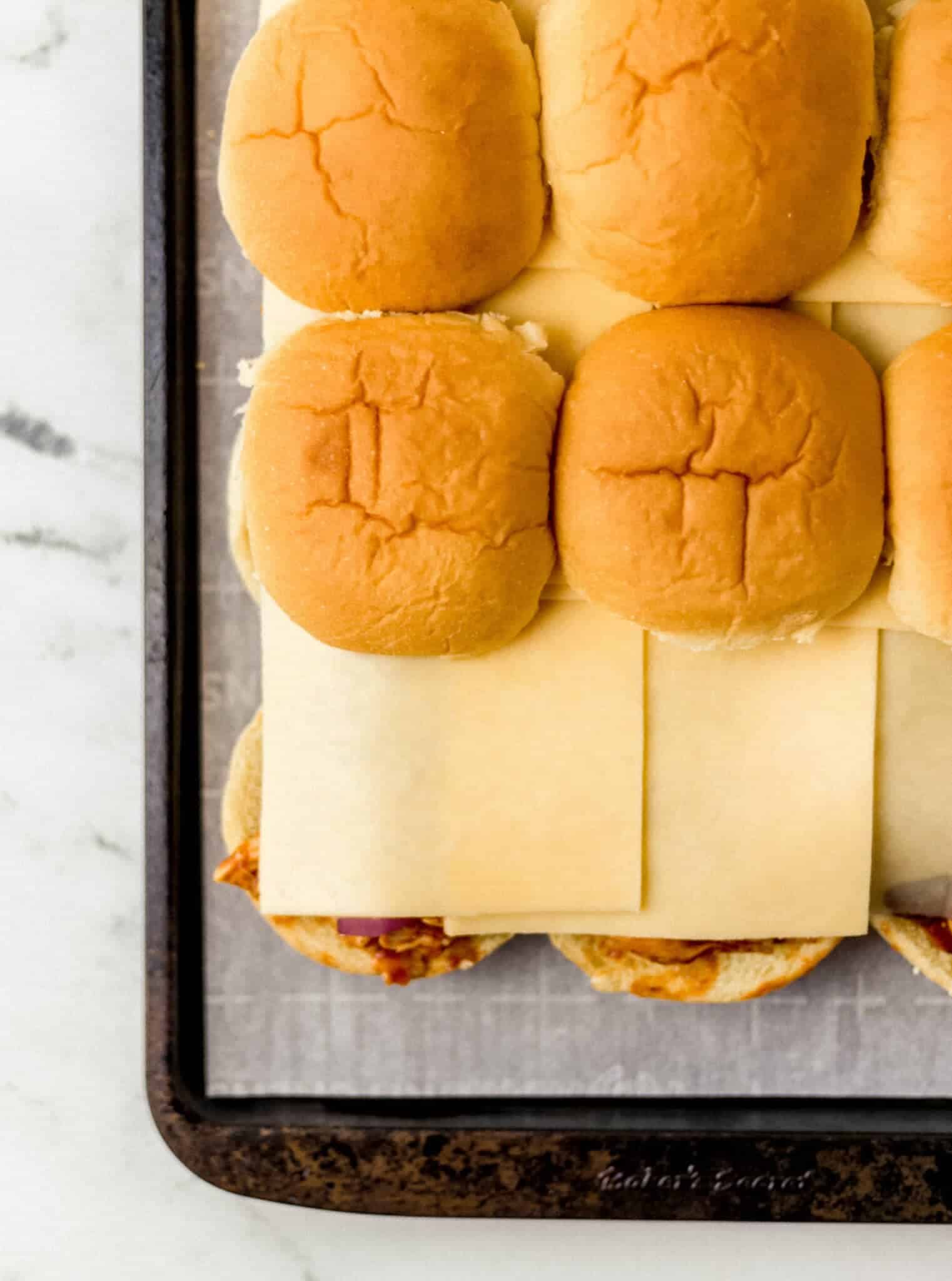 cheese and top of slider bun on top of sliders 